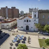 Fachada colonial blanca del Santuario Virgen de los Milagros y el lateral del Colegio de la Inmaculada Concepción bajo un cielo despejado.
